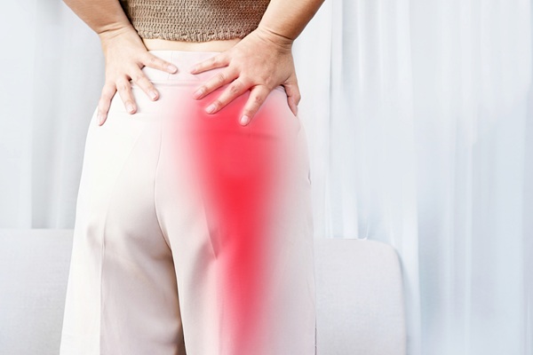Person holding the hip and upper thigh, representing care for hip pain, sciatica, and lower-body discomfort