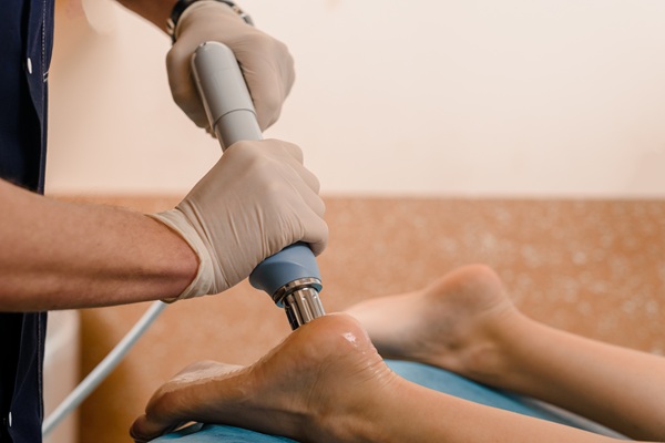 Targeted therapy being applied to the heel and ankle, representing treatment for foot pain, inflammation, and recovery